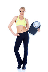 Image showing Happy blond woman standing with weight scale