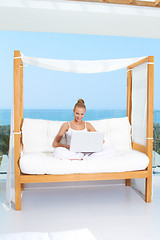 Image showing Woman on canopied seat with laptop