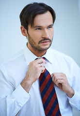 Image showing Attractive man straightening his tie