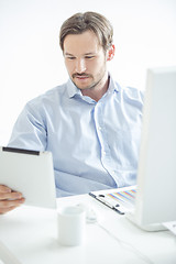 Image showing Businessman checking his work at tablet