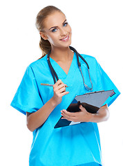 Image showing Cute nurse looking at the camera and smiling with writingpad