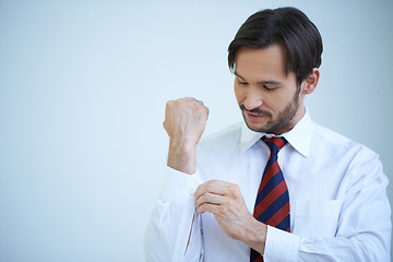 Image showing Young man buttoning his cuffs