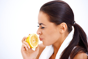 Image showing Woman holding lemon while making a face