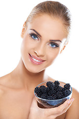 Image showing Smiling girl holding blackberries on hand