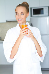 Image showing Stylish woman drinking healthy orange juice