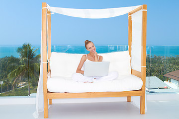 Image showing Woman on canopied seat with laptop