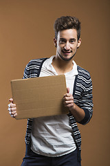 Image showing Young man holding a card board