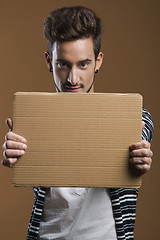 Image showing Young man holding a card board