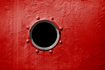 Image showing Porthole on red wall of old ship