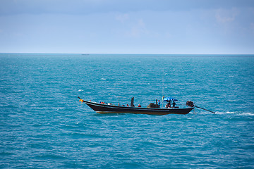 Image showing Old fishing boat goes by sea - fishermen working