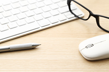 Image showing Keyboard, pen, mouse and glasses on the working desk 