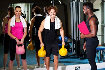 Image showing Happy man and woman lifting kettlebell