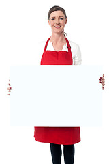 Image showing Lady wearing apron holding white blank ad board