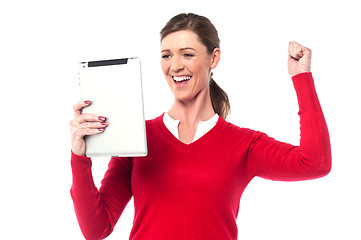 Image showing Excited pretty woman holding touch pad