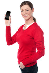 Image showing Woman showing her new mobile phone to the camer