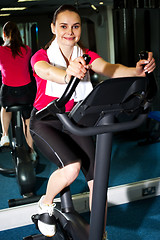 Image showing Athletic woman cycling at the gym