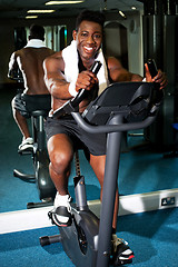 Image showing Muscular man on excercise bike at the gym