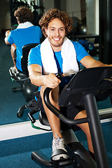 Image showing Handsome man at the gym doing static cycling