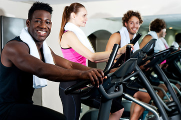 Image showing Gym trainer exercising along with his trainees