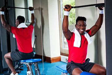 Image showing Confident young african guy working out in gym