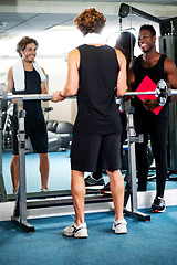 Image showing Smart young guy lifting barbells in gym