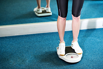 Image showing Cropped image of a woman measuring weight