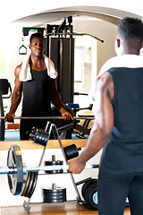 Image showing Young bodybuilder lifting the barbell