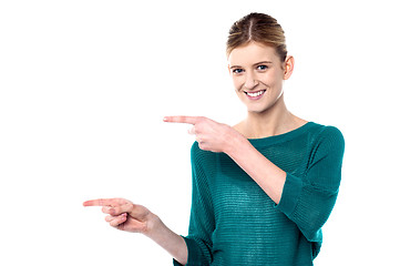 Image showing Attractive girl pointing towards copy space area