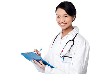 Image showing Pretty female doctor writing prescription