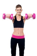 Image showing Trainer holding dumbbells in her outstretched arms