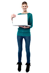 Image showing Full length shot of smiling girl holding laptop