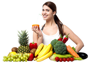 Image showing Pretty girl sipping orange juice with a straw