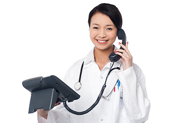 Image showing Young lady doctor answering phone call