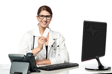 Image showing Smiling lady doctor holding pack of medicine