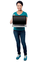 Image showing Salesgirl presenting brand new laptop for sale