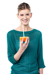 Image showing Girl sipping orange juice through straw