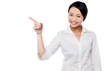 Image showing Happy young girl pointing at copy space area