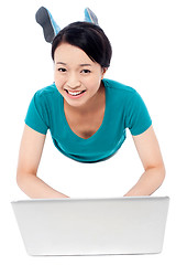 Image showing Girl lying on the studio floor and using laptop