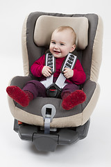 Image showing toddler in booster seat for a car in light background