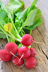 Image showing Small garden radish isolated on old wooden background