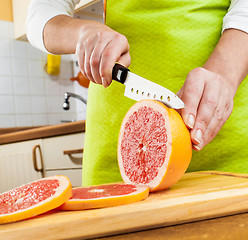 Image showing Woman's hands cutting grapefruit