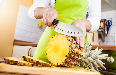 Image showing Woman's hands cutting pineapple