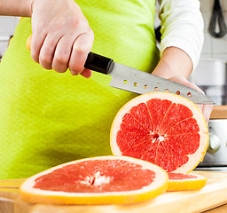 Image showing Woman's hands cutting grapefruit