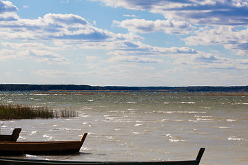 Image showing Majestic cloudscape and stationary boats at lakeside