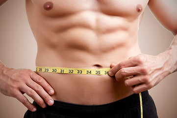 Image showing Fit Man Measuring His Waist