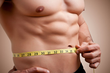 Image showing Fit Man Measuring His Waist