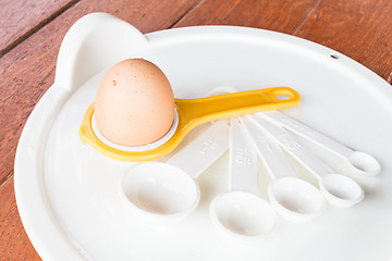 Image showing Bakery preparing with egg, yolk separator and spoon 