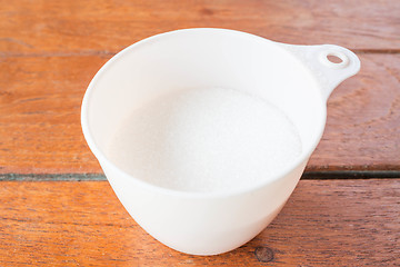 Image showing Bakery white sugar measured in plastic  cup 