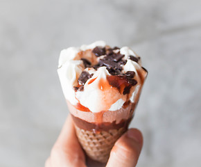 Image showing Melted ice cream in waffle cone in hand