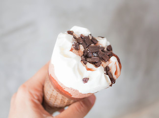 Image showing Melted ice cream in waffle cone in hand